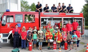 Zum obligatorischen Erinnerungsfoto stellten sich die Kinder mit einigen Geräten der Feuerwehr vor dem großen Tanklöschfahrzeug auf. Foto: Ernst Häge 